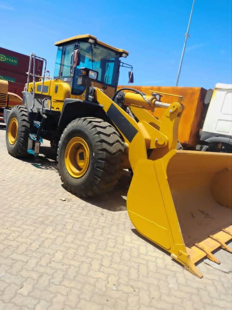 Yellow wheel loader parked in a port yard